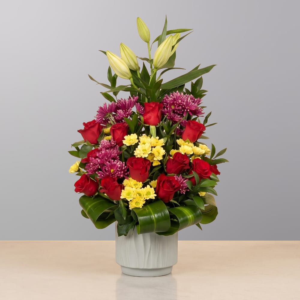 A luxurious floral arrangement featuring premium blooms, delicate seasonal flowers, and fresh greenery, elegantly arranged in a decorative vase.