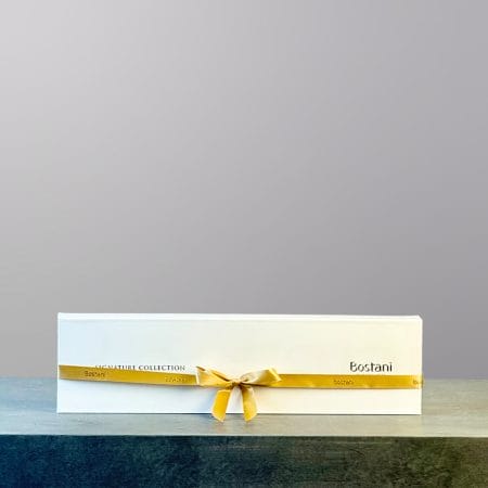 A rectangular box of chocolates with a golden ribbon made by Bostani.