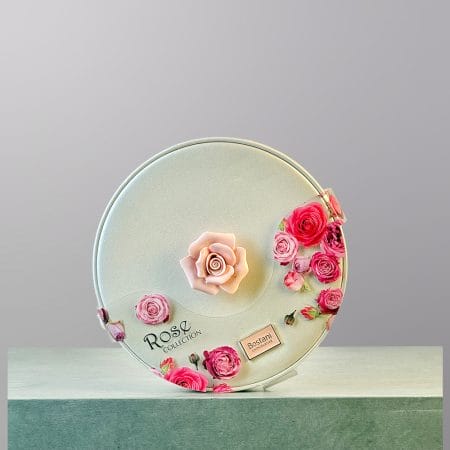 A circular, white box of chocolates made by Bostani.