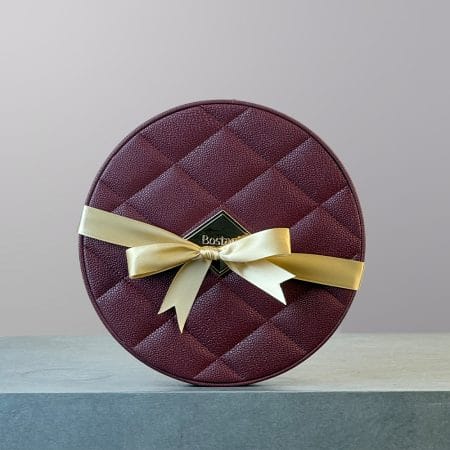 An oval maroon coloured box of chocolates made by Bostani.